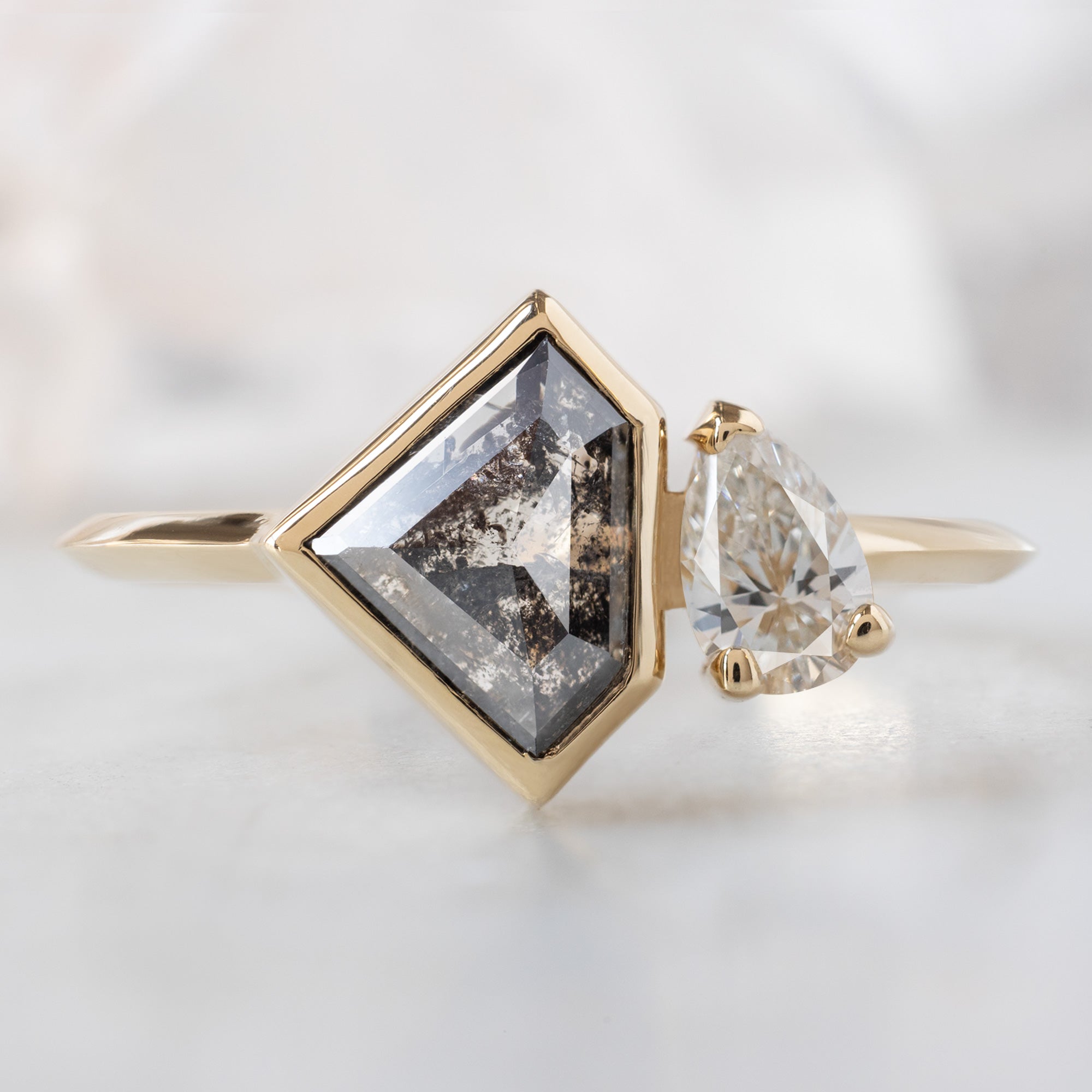 The You & Me Ring with a 1.18ct Shield Salt and Pepper Diamond in 14K Yellow Gold on White Marble