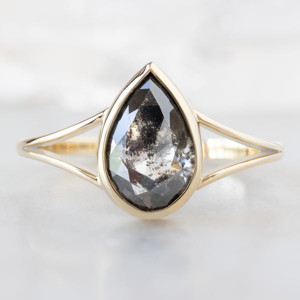 The Magnolia Ring with a 1.44ct Lab Grown Salt and Pepper Pear Diamond in 14K Yellow Gold on White Marble Tile