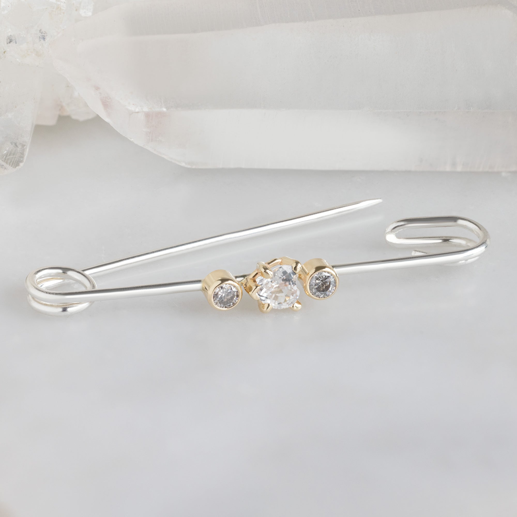 White Sapphire Safety Pin Brooch in Sterling Silver on White Marble Surface